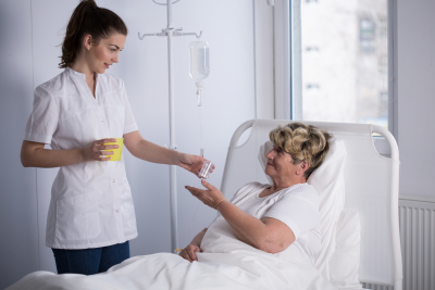 Nurse giving medicine to elderly hospice patient